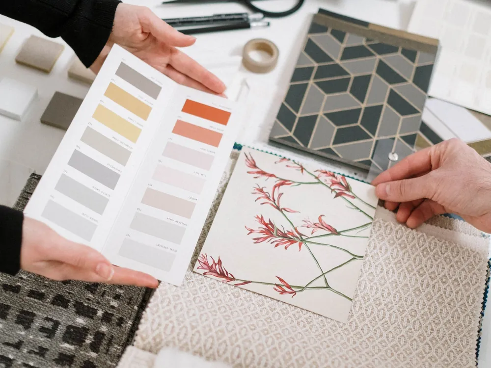Hands reviewing colour and pattern samples on a design board